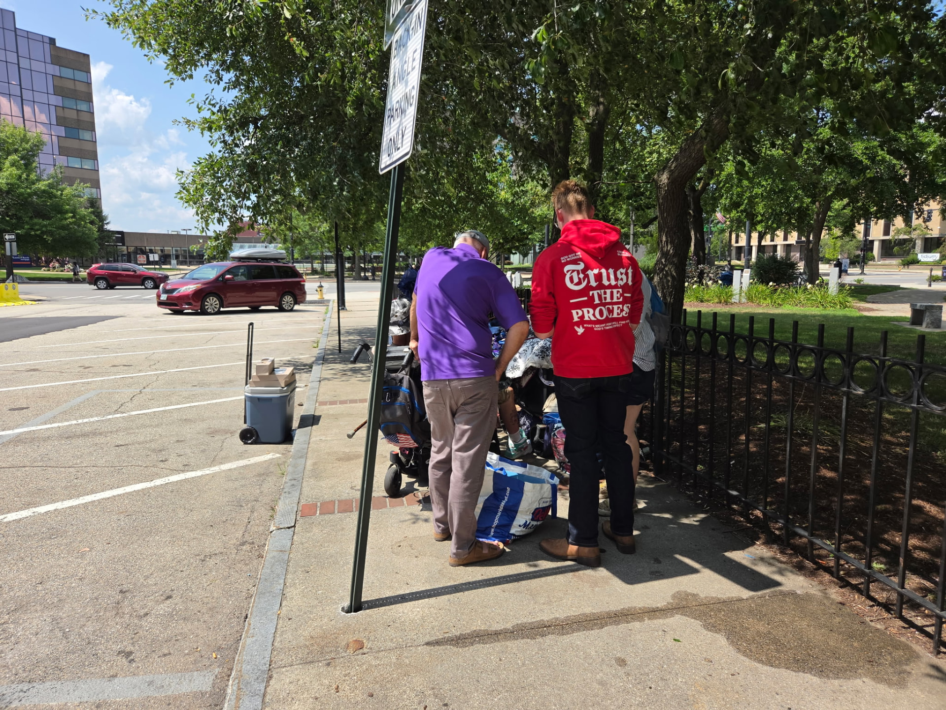 Two volunteers helping a neighbor with belongings during street outreach