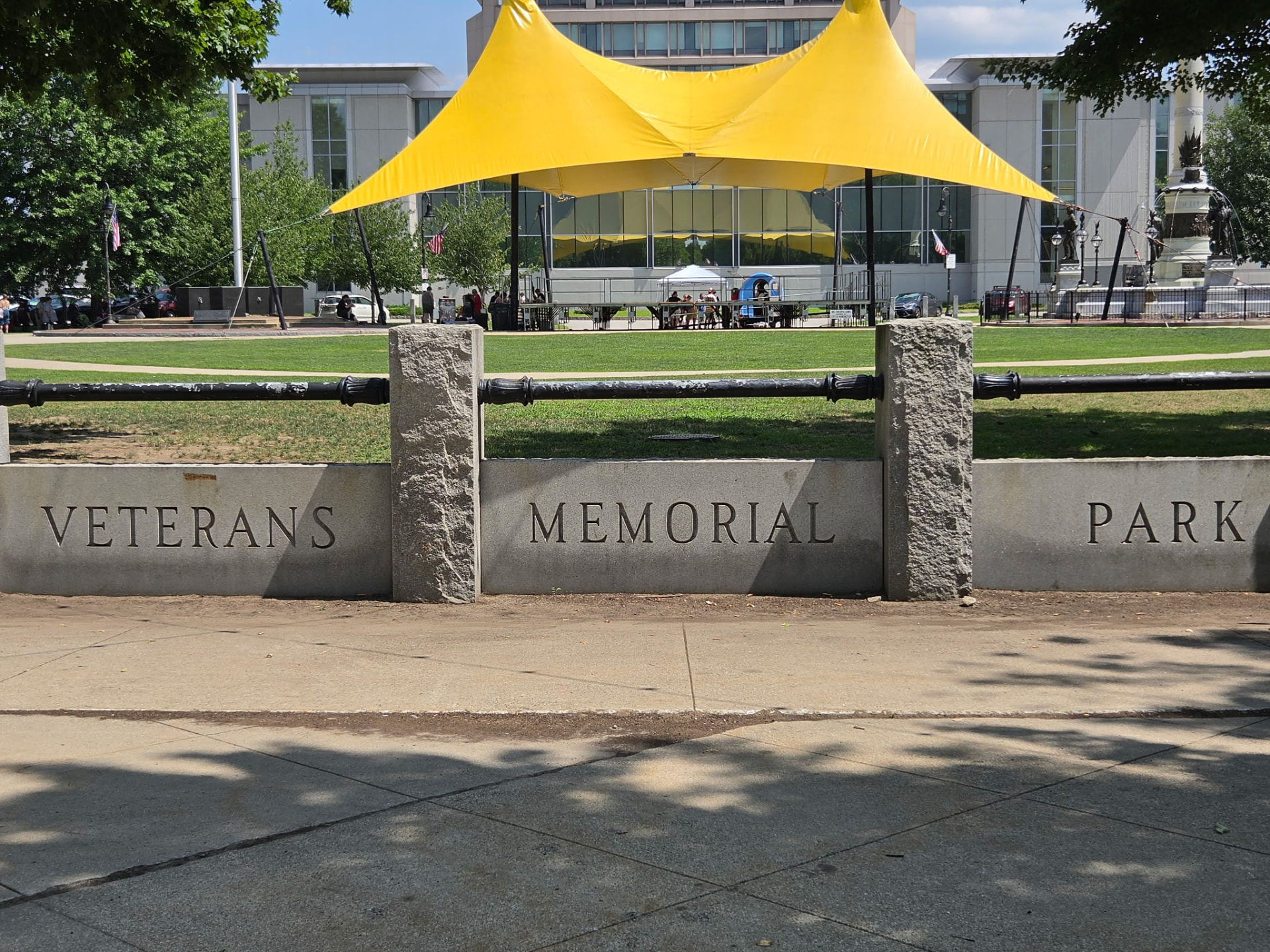 Veterans Memorial Park with a community gathering tent set up on the lawn
